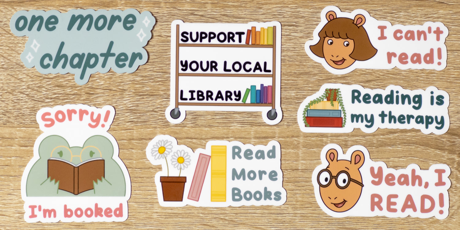 7 glossy bookish stickers. Designs include a blue "One More Chapter" sticker, a Book Cart with colorful books and text that says "Support Your Local Library" sticker, "Read More Books" with daisies and books sticker, "Reading is My Therapy" with a stack of books and a potted plant sticker, a Frog with glasses reading a book with the text "Sorry! I'm Booked" sticker, an Arthur design with the text, “Yeah, I read!” sticker, and a D.W. design with the text, “I can’t read!” sticker