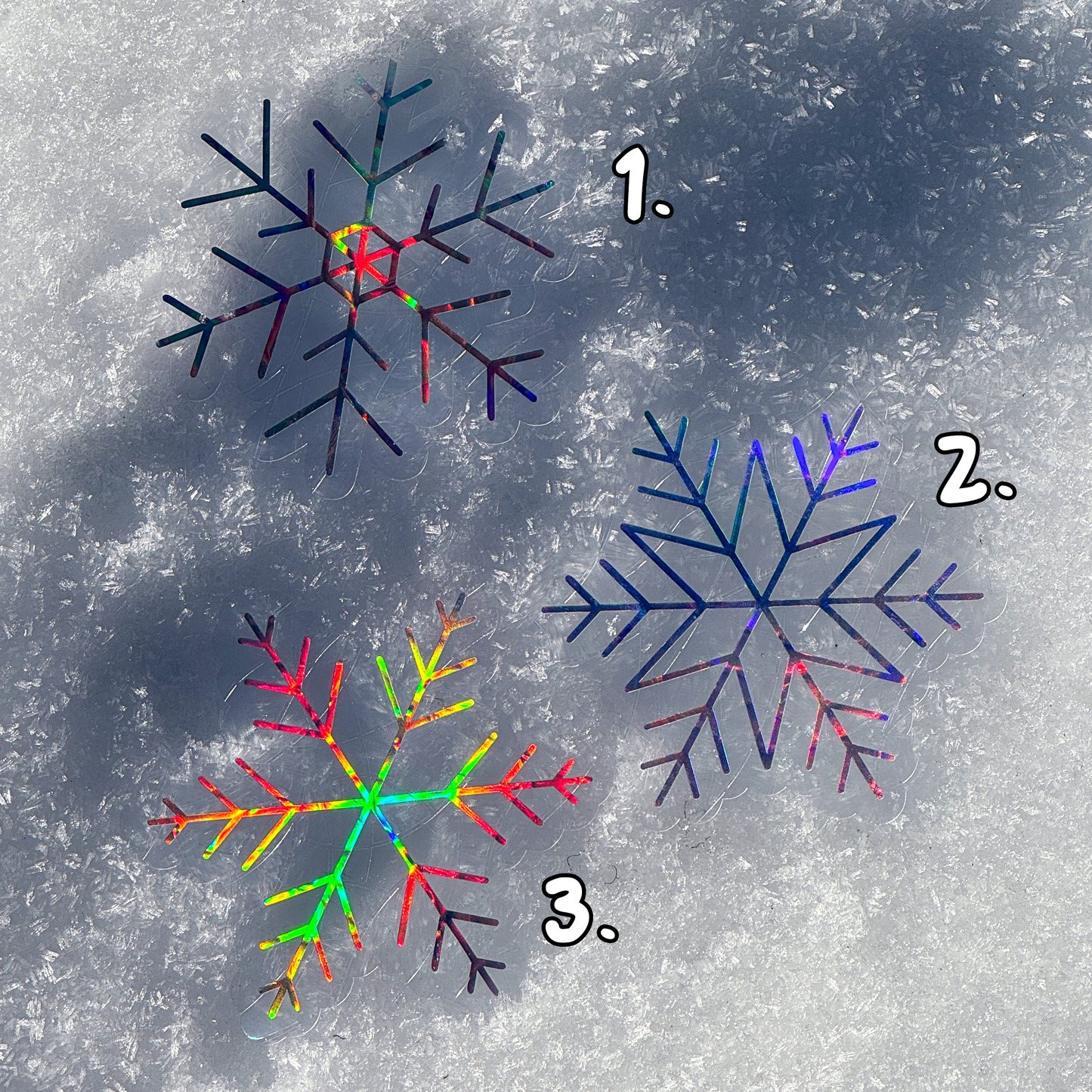 3 Holographic cozy winter snowflake suncatcher cling decal stickers. Resting on snow. 3 different designs available