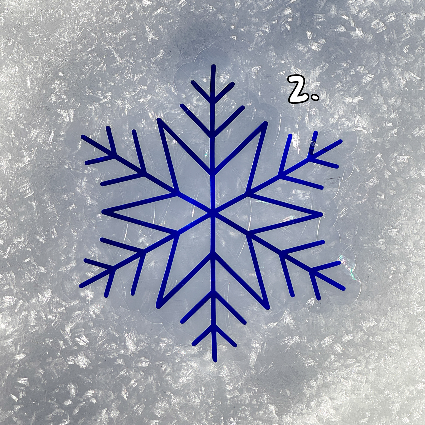 Second design. Cozy winter snowflake suncatcher cling decal sticker.
The suncatcher has changed color to a deep blue. Resting on snow