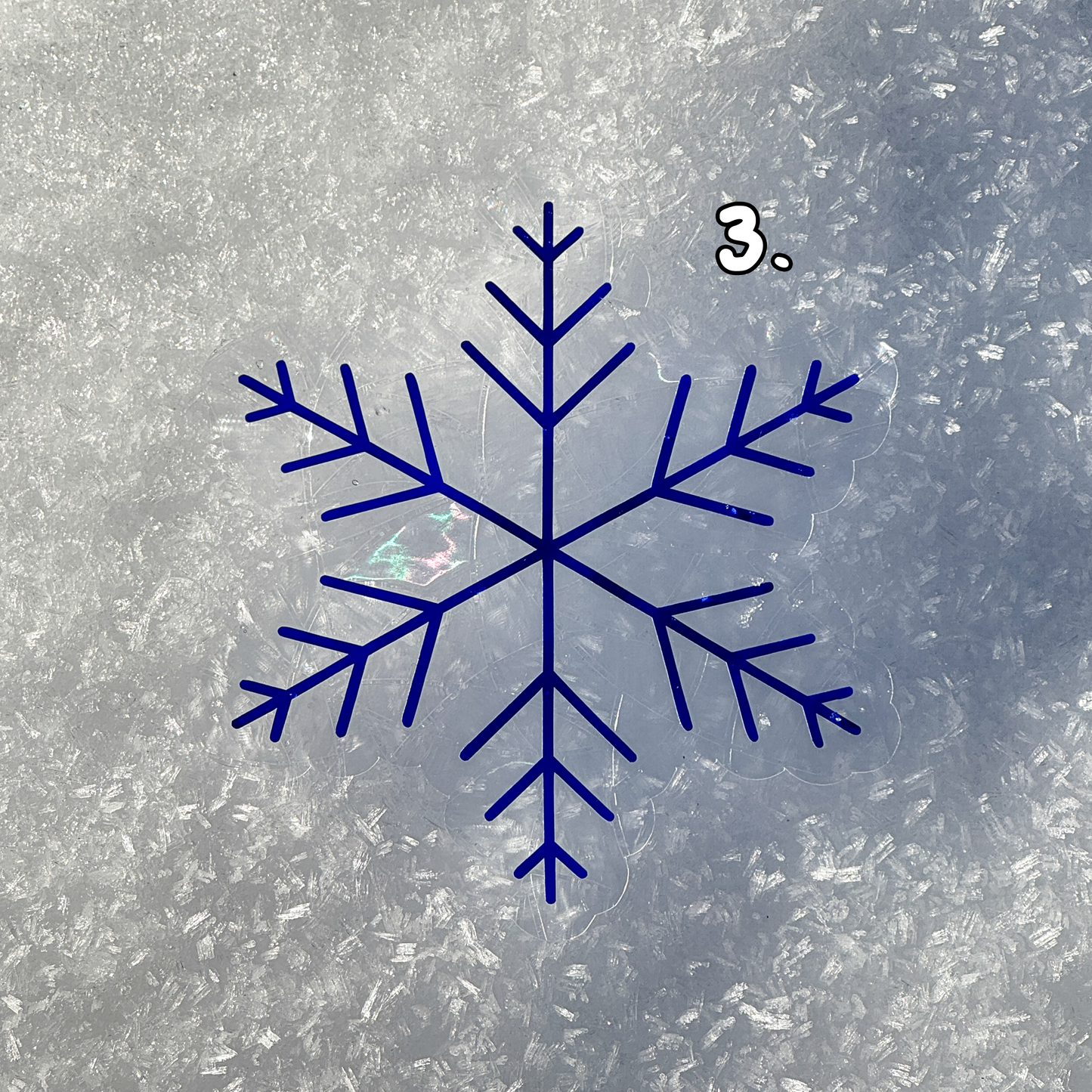 Third design. Cozy winter snowflake suncatcher cling decal sticker.
The suncatcher has changed color to a deep blue. Resting on snow